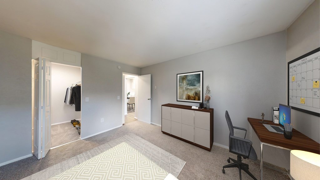 A room with a desk, chair, and a painting on the wall.