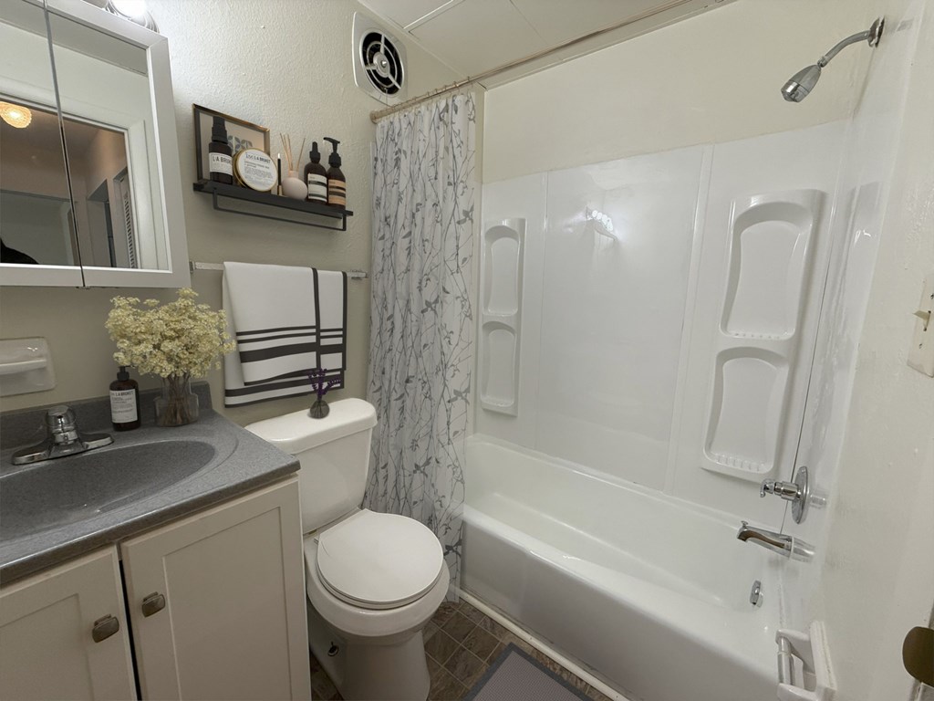 A white bathroom with a toilet, sink, and bathtub.