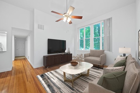 A living room with a white ceiling fan and a white coffee table.