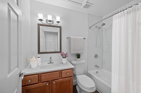 A white bathroom with a toilet, sink, and shower.
