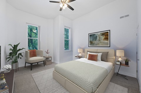 A bedroom with a large bed and a ceiling fan.