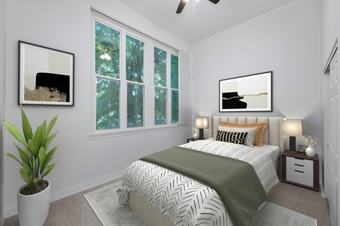 A bedroom with a bed, a plant, and two framed pictures on the wall.