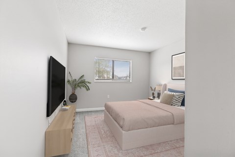 A bedroom with a bed, a television, and a plant.