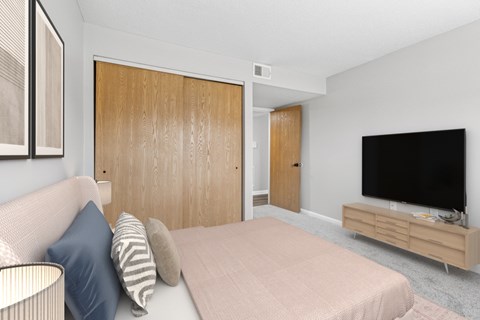 A bedroom with a bed, a couch, and a television.