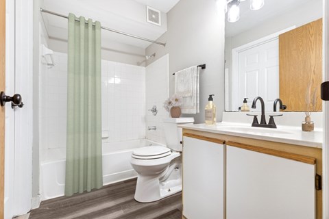 A white toilet sits in a bathroom next to a sink.