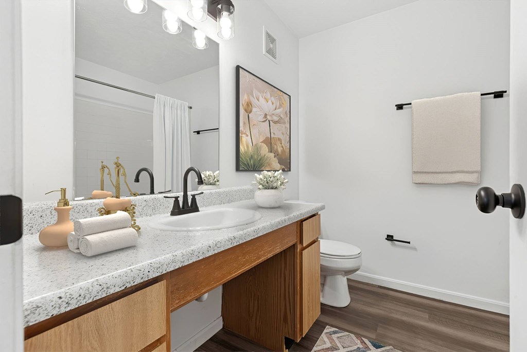 A bathroom with a white countertop and a towel hanging on the wall.