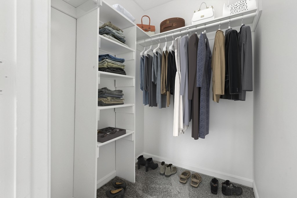 A white closet with clothes and shoes.