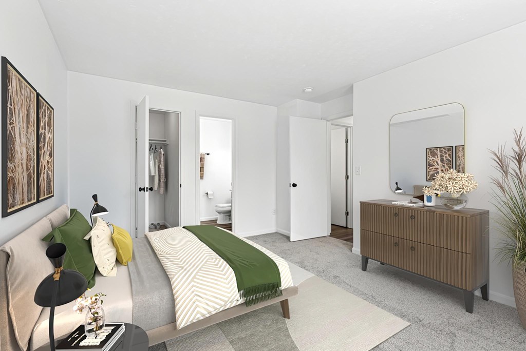 A bedroom with a bed, nightstand, and a plant.