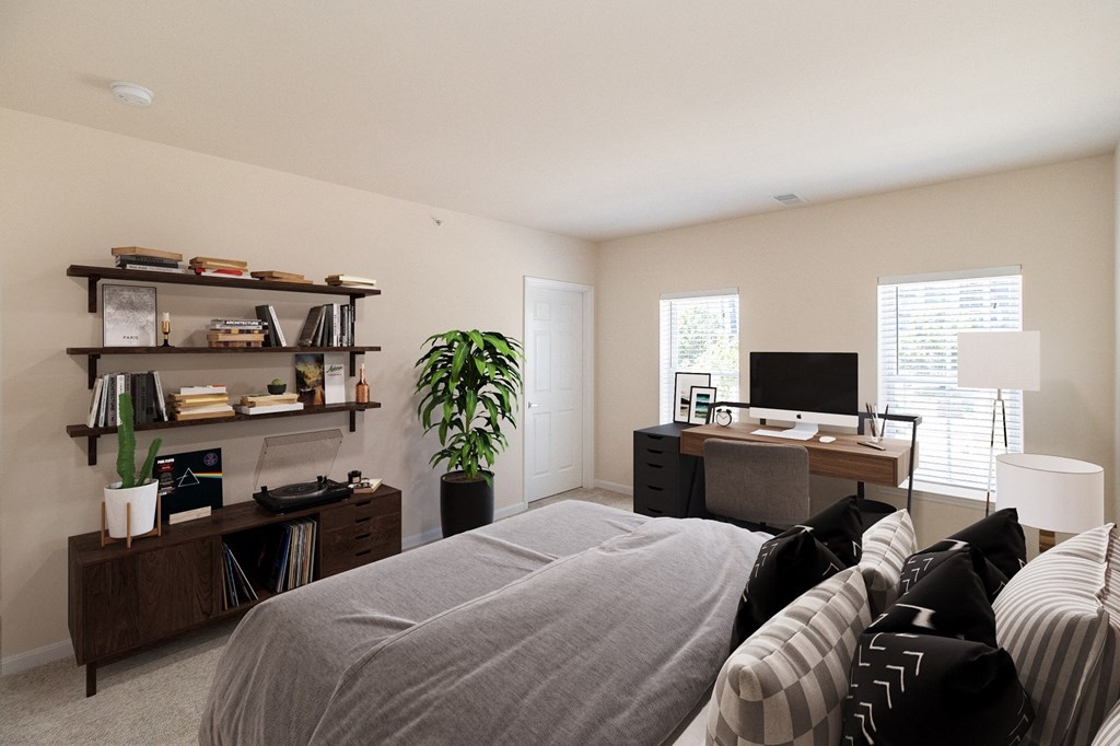a bedroom with a bed and a desk with a computer