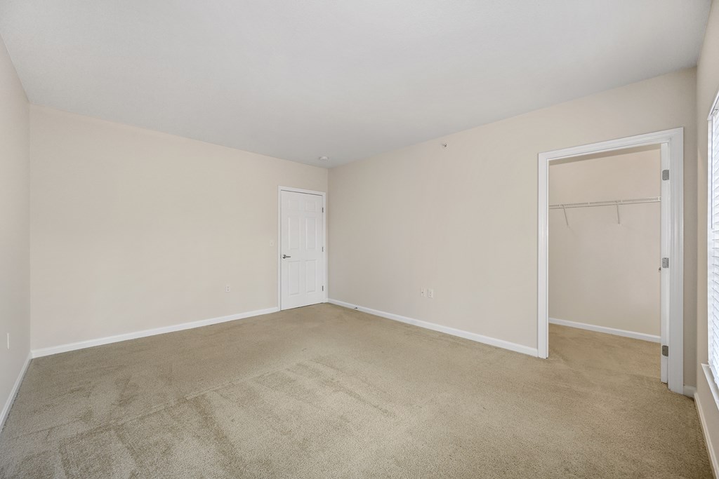 an empty living room with carpet and a closet