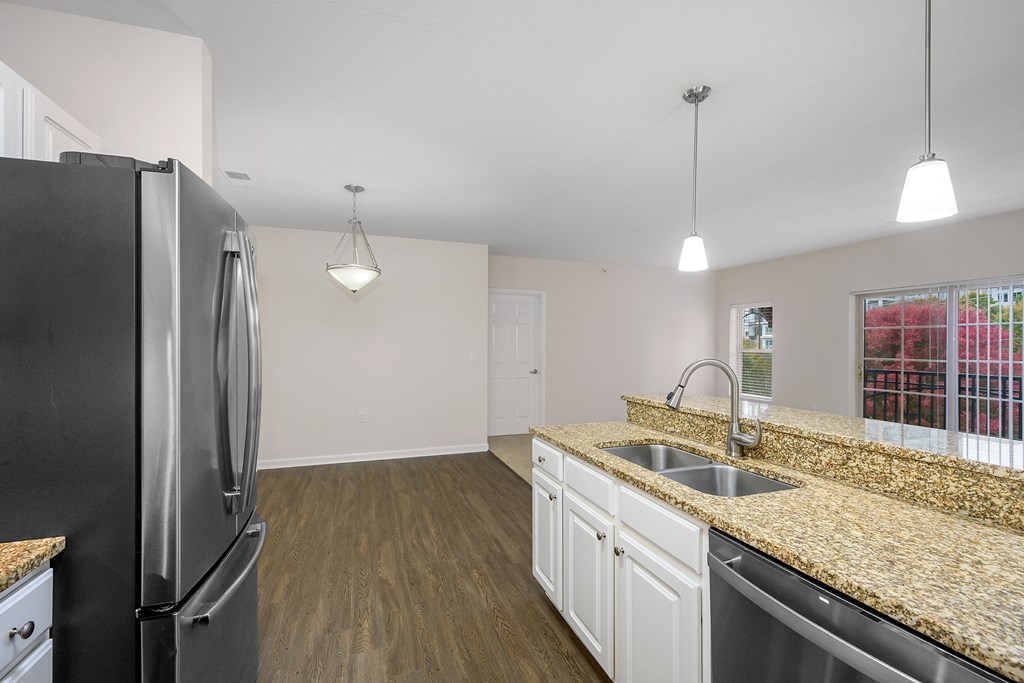 a kitchen with granite counter tops and a stainless steel refrigerator