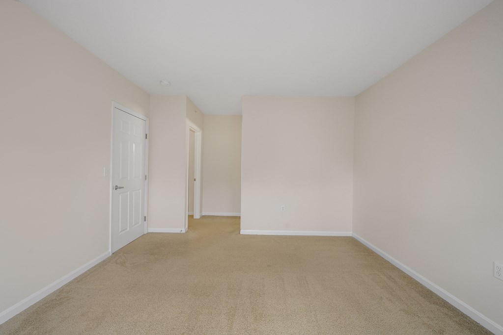 a bedroom with a carpeted floor and white walls