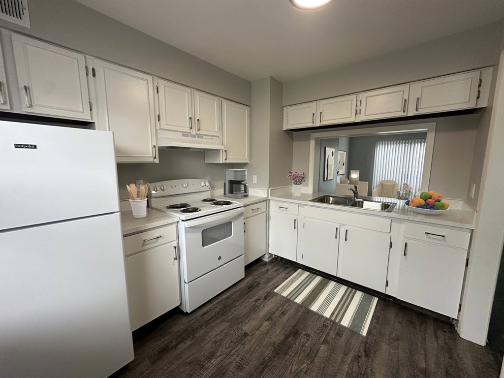 A kitchen with white appliances and cabinets.