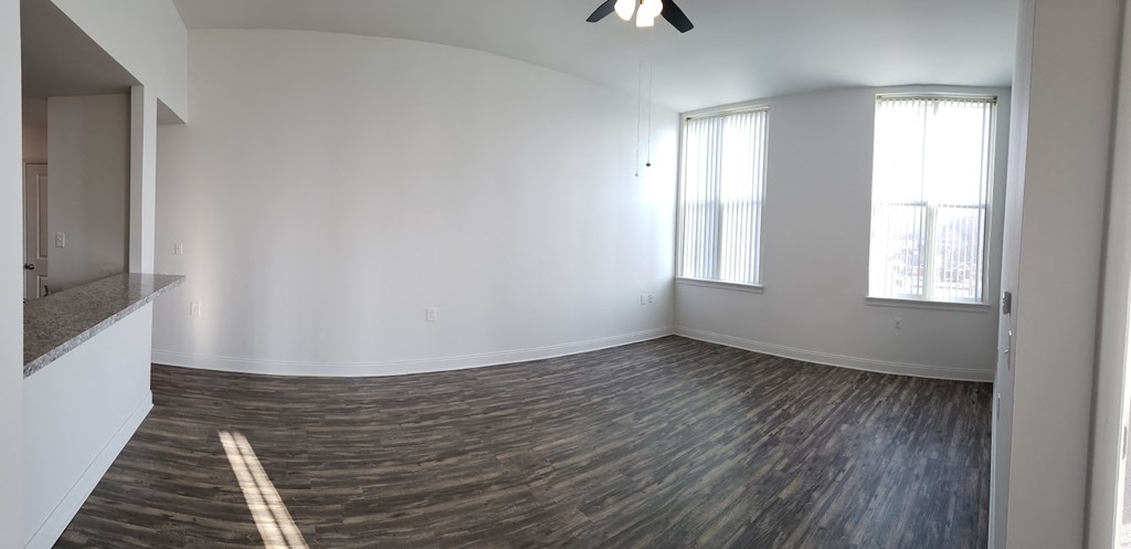 an empty living room with white walls and a window