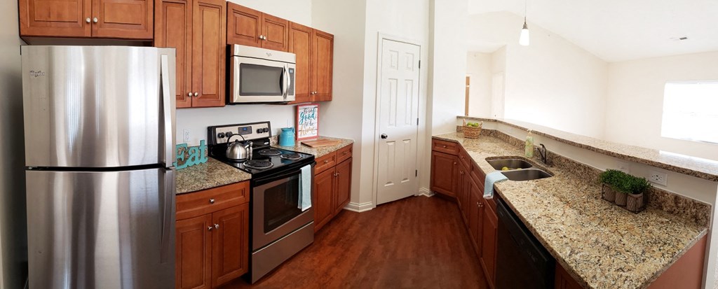 a kitchen with stainless steel appliances and granite counter tops