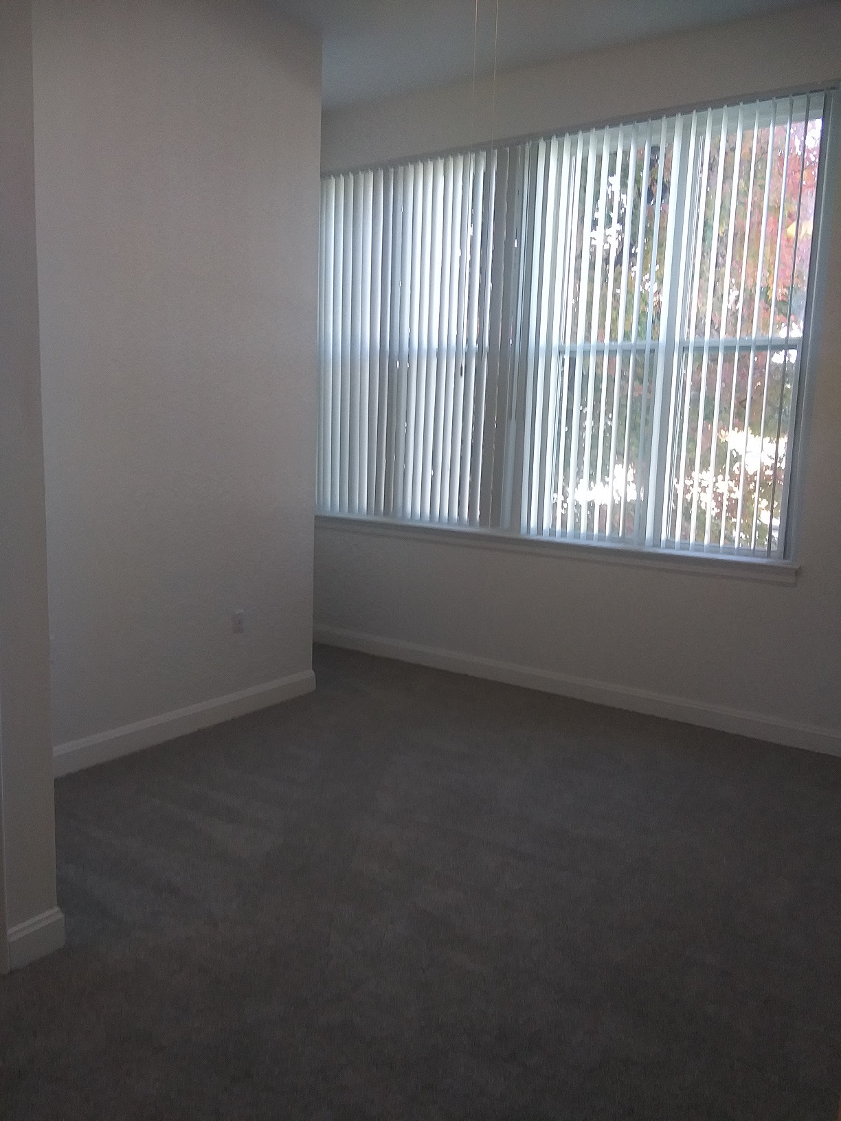 an empty living room with a large window