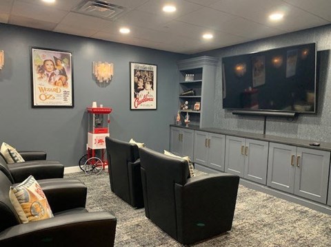 a living room with chairs and a television