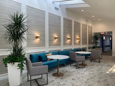 a lobby with a blue couch and tables and chairs