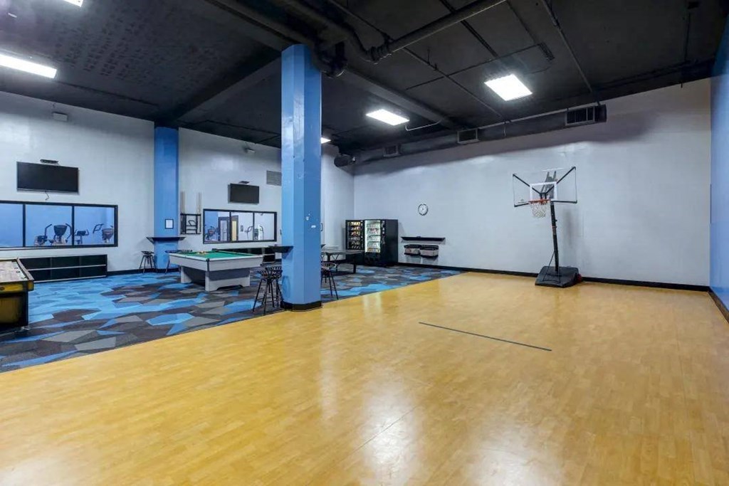 a gym with a wooden floor and a basketball court