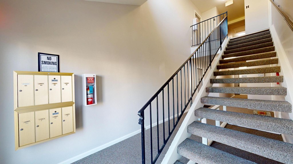 A staircase with a no smoking sign and a fire extinguisher on the wall.