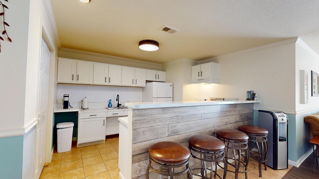 A kitchen with white cabinets and a grey counter.