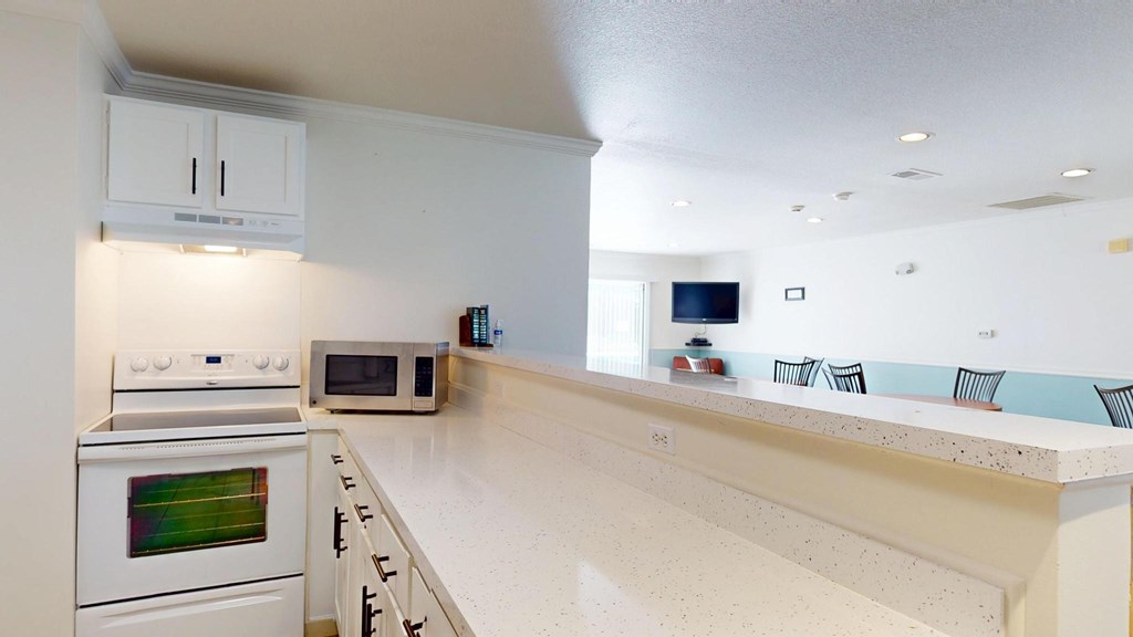 A kitchen with white appliances and a white countertop.