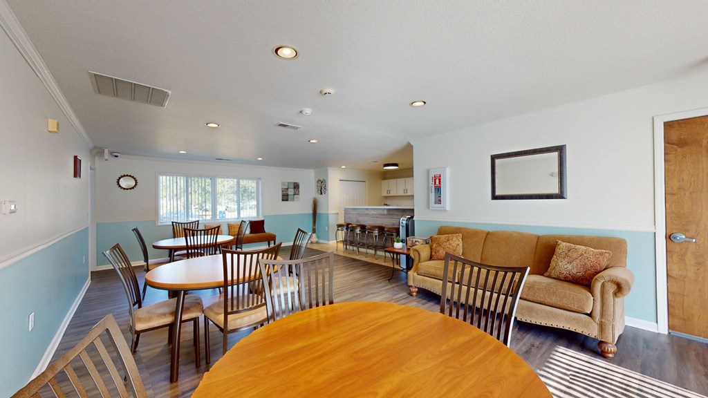 A living room with a couch, chairs, and a dining table.