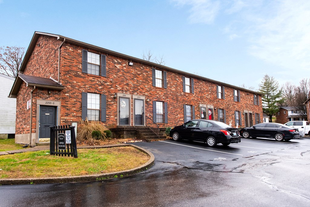 an old brick building with cars parked outside