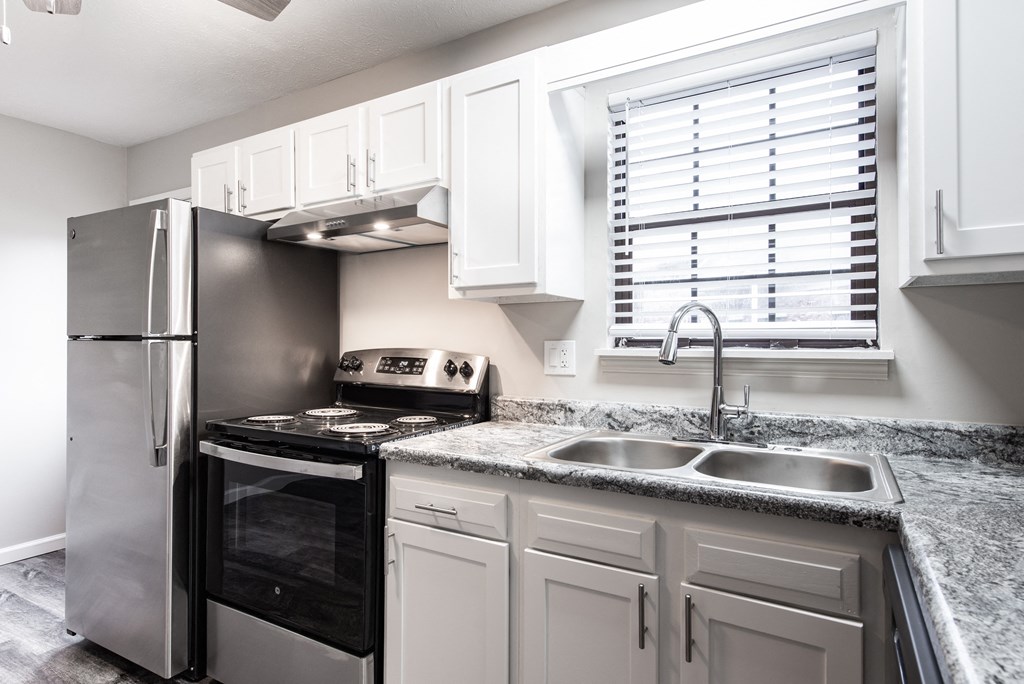 an updated kitchen with granite counter tops and stainless steel appliances