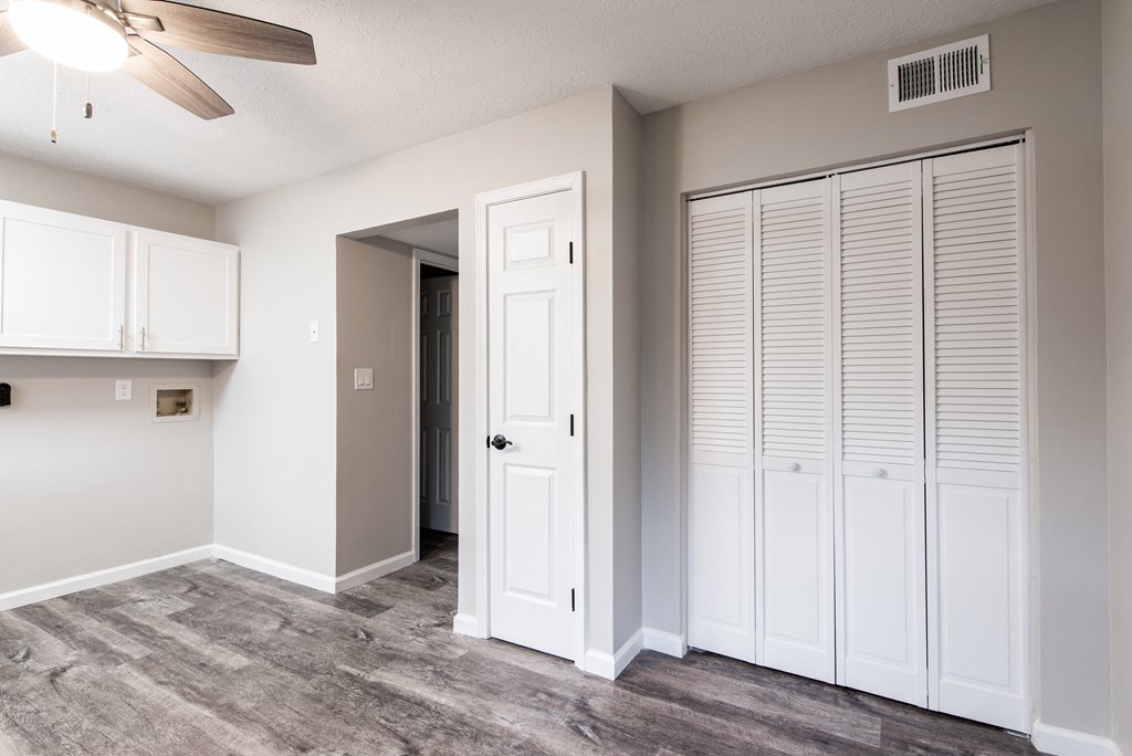 an empty room with a closet and a ceiling fan