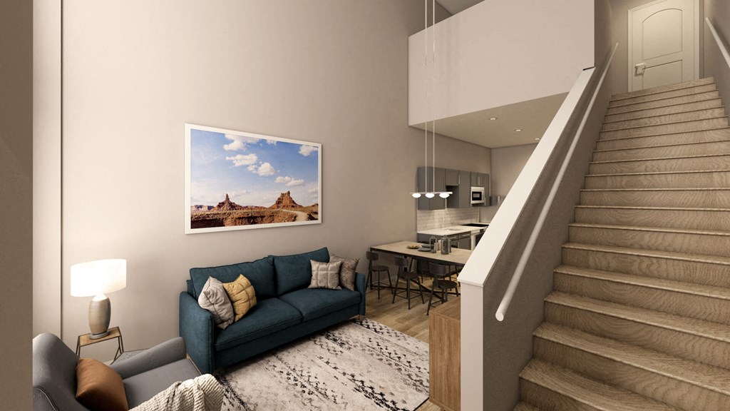 a living room with a blue couch and a staircase at Adelphi Quarter, Columbus, Ohio