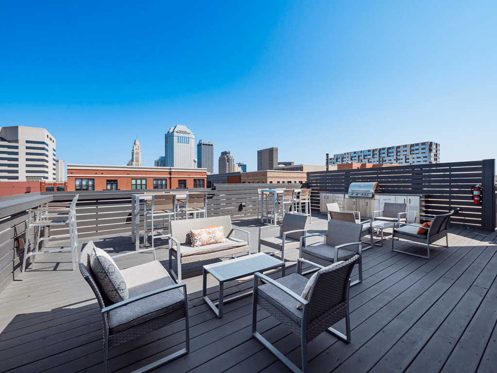 A rooftop patio with chairs and a table.