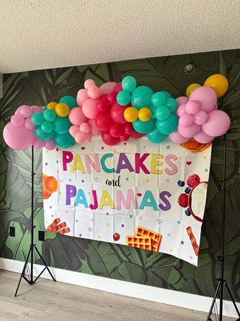 a banner with balloons and a sign that says pancakes and pajamas