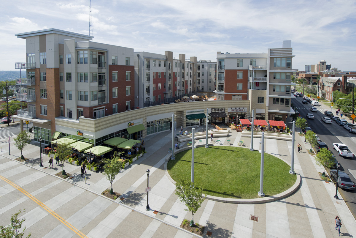 an aerial view of a city street with buildings and a lawn