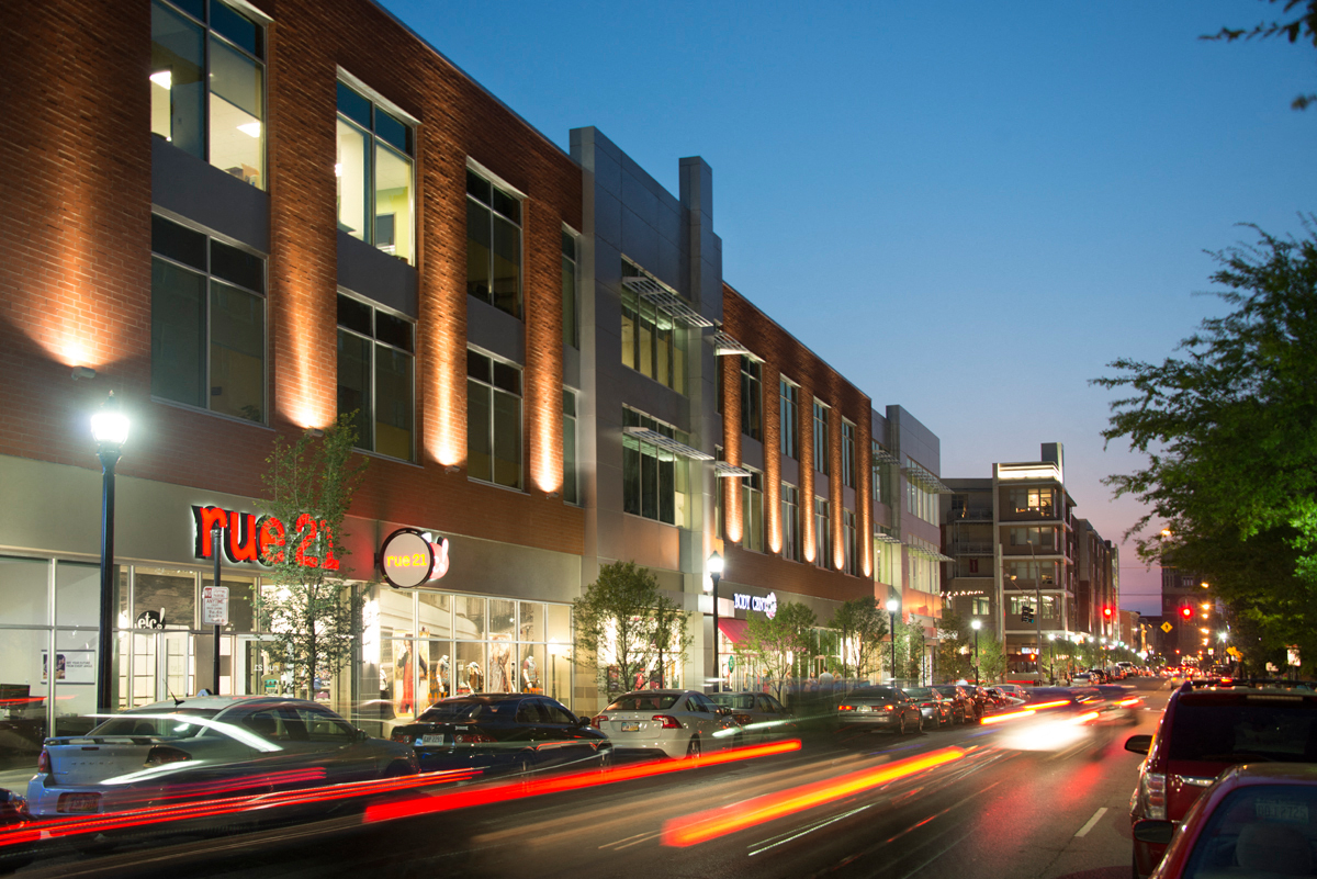 a night view of a city street with cars and a building