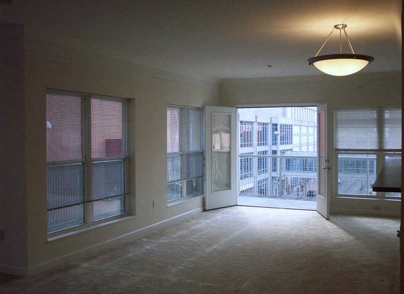 an empty living room with a door to a balcony