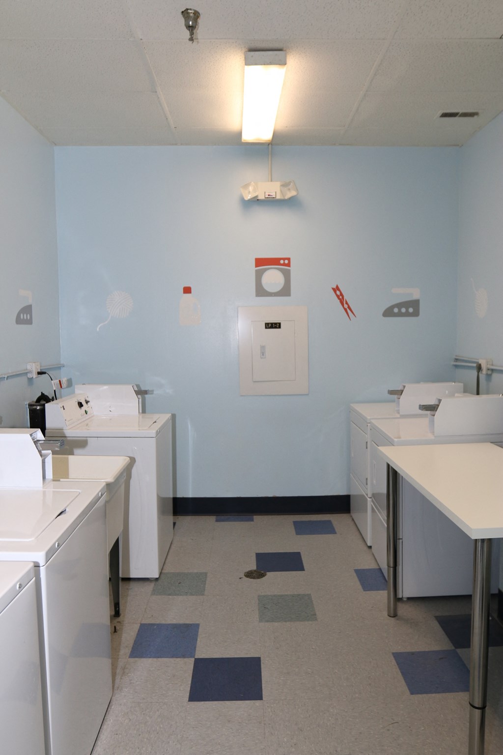 a laundry room with sinks and machines and a blue wall