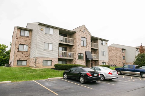 an apartment building with cars parked in front of it