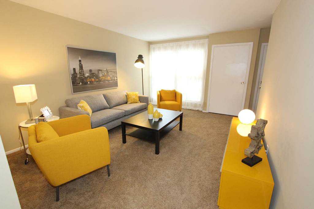 a living room with yellow couches and a table