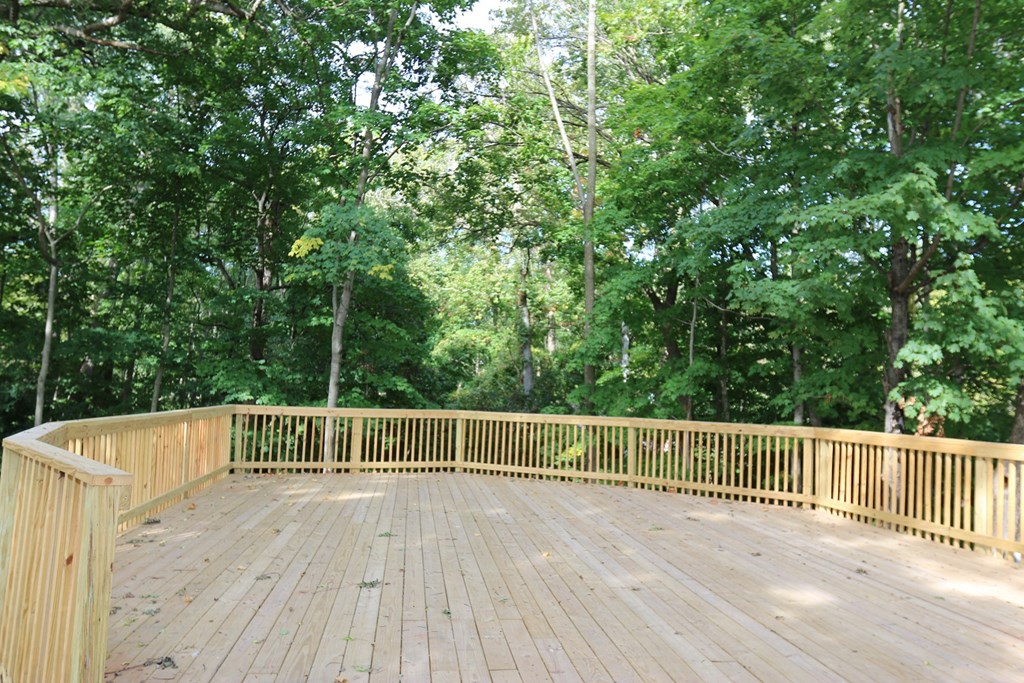 a covered deck with trees in the background