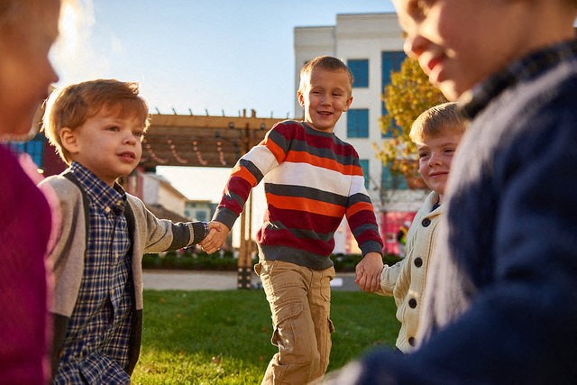 a group of young boys holding hands and laughing