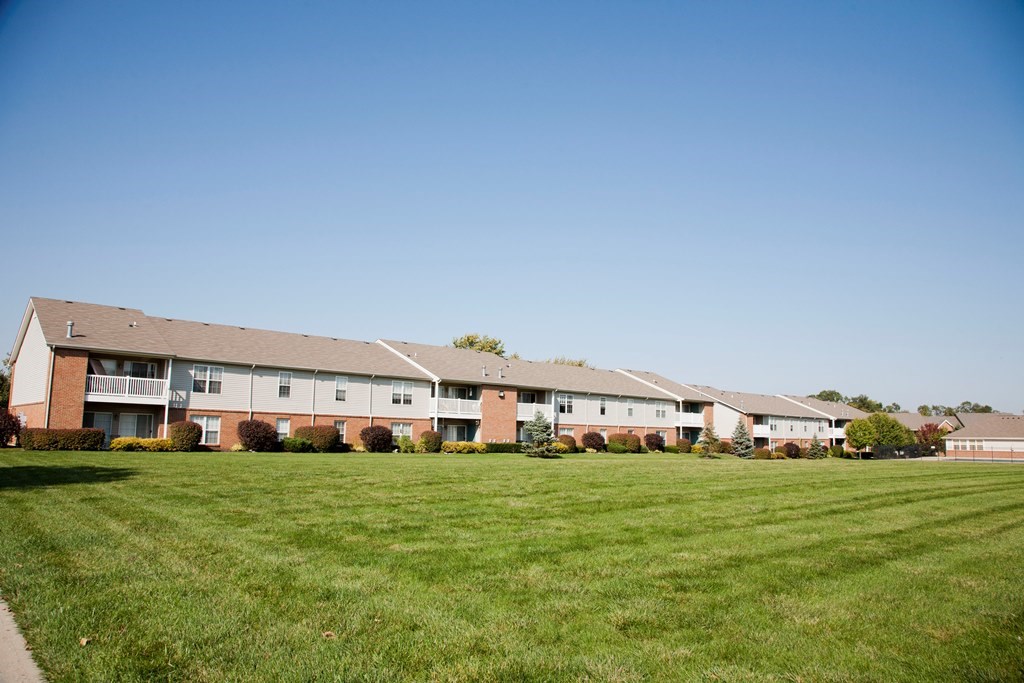 Apartment complex with green grass in front.