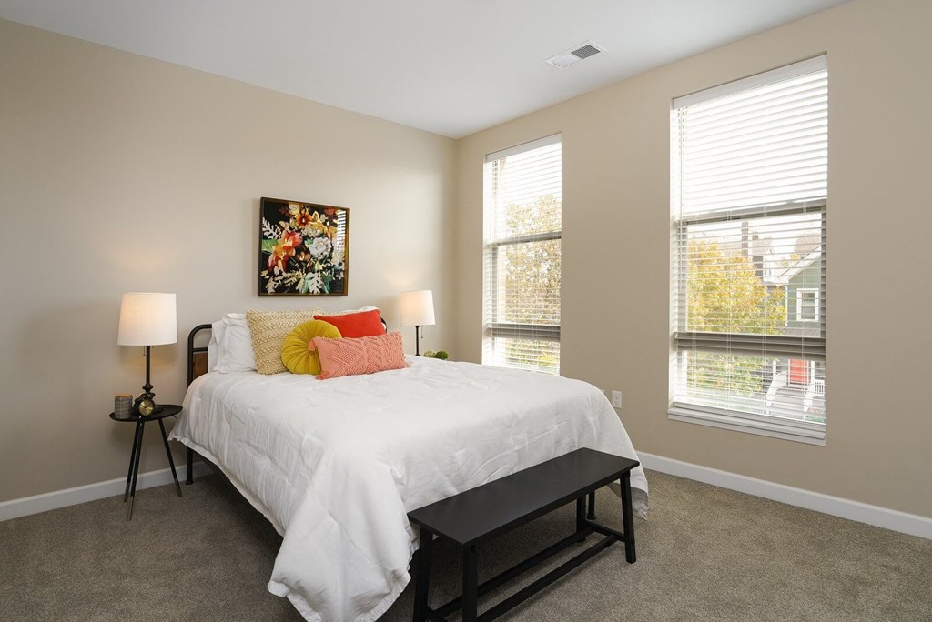 a bedroom with a white bed and two windows at Adelphi Quarter, Columbus