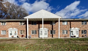 a brick apartment building with white doors and windows - Photo Gallery 34