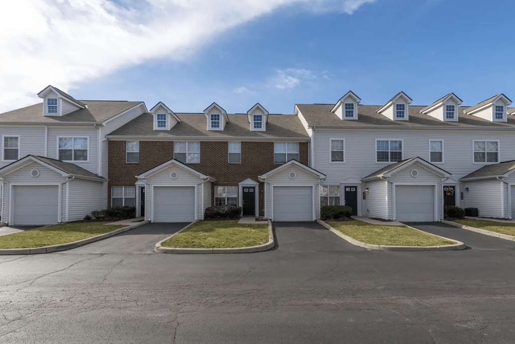 a row of houses with white roofs on a street at Traditions at Slate Ridge, Reynoldsburg, OH