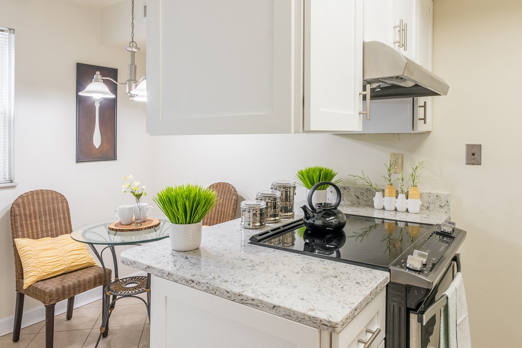 Kitchen with white cabinets and a counter with a sink and a stove at Indian Creek Apartments, Cincinnati