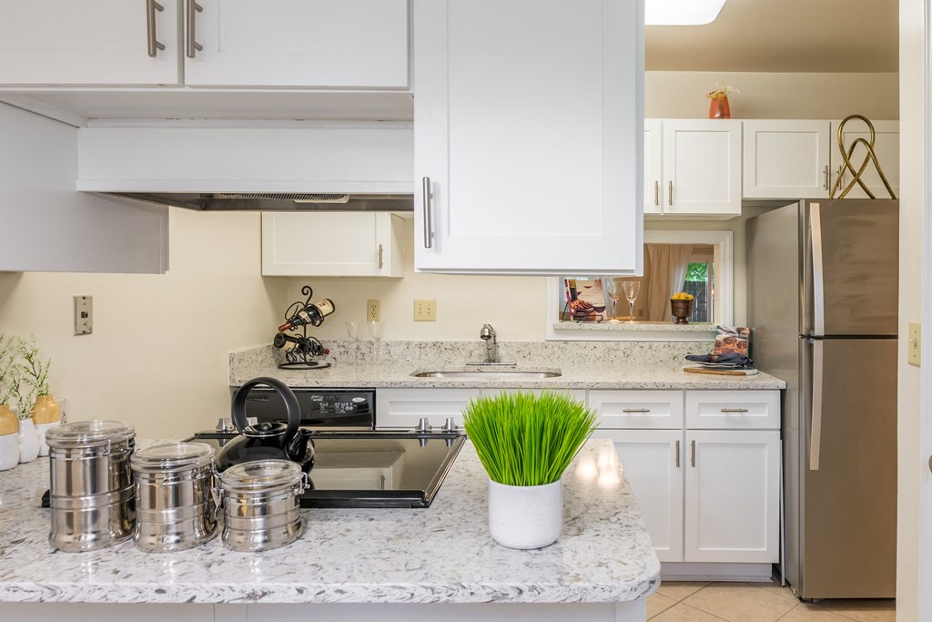 Kitchen with stainless steel appliances and white cabinets at Indian Creek Apartments, 45236