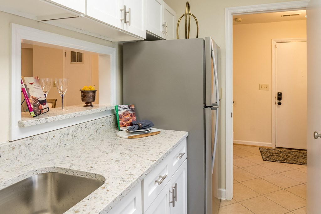 Kitchen with white cabinets and a sink and a refrigerator at Indian Creek Apartments, Cincinnati, Ohio