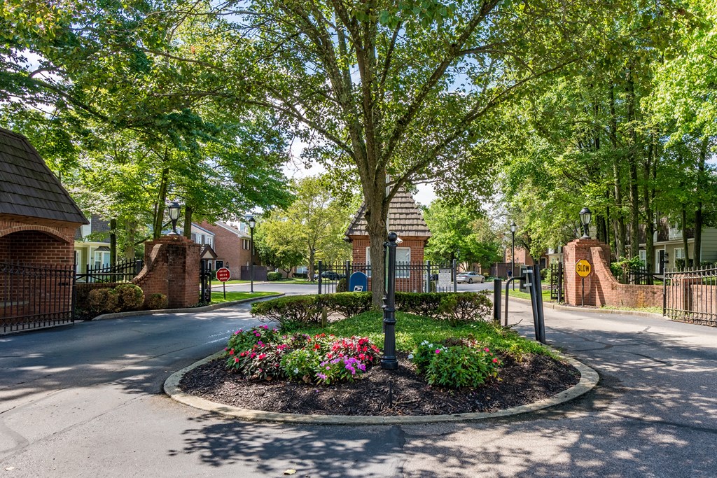 Roundabout with a tree and flowers in the middle of a street at Indian Creek Apartments, Cincinnati