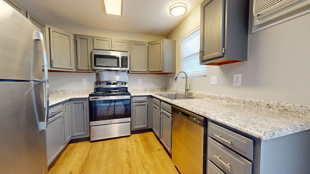 a kitchen with granite counter tops and stainless steel appliances